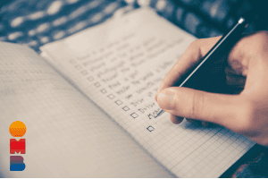 Een hand schrijft op een notebook doelen op - Doelen stellen