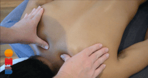 Twee handen van een masseur masseren de schouderspieren van een klant