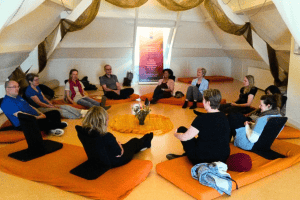 Een groep mensen zit in een kring tijdens de Massage opleiding