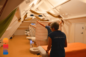In een groepsles massage zie je dat iedereen afgeschermt wordt doordat de massagedoeken worden opgehouden.